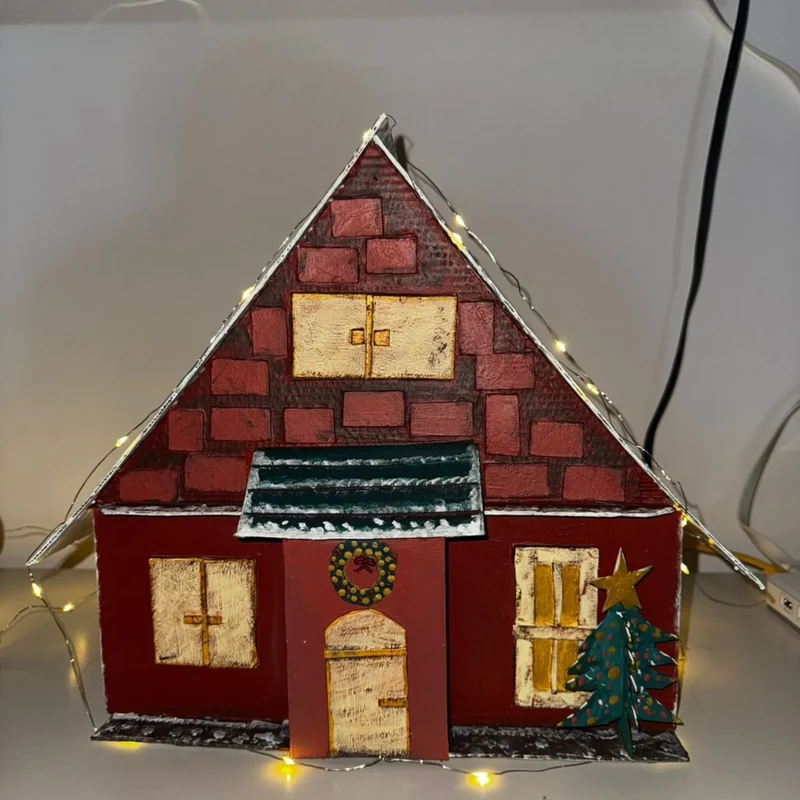 Casinha rústica natalina com tijolinhos, guirlanda na porta, árvore de Natal e luzes