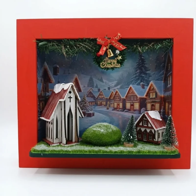 Quadro 3D de Natal em caixa vermelha com igrejinha, casas com neve e vila ao fundo
